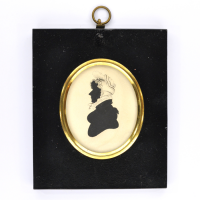 Front of silhouette, in frame, with woman looking left, wearing a bonnet.