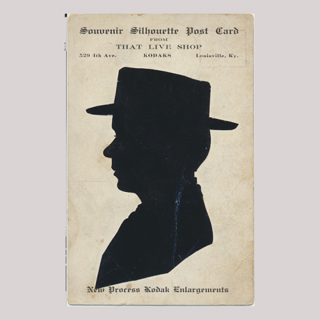 
        Front of silhouette, with man looking left, wearing a hat, with inscriptions.