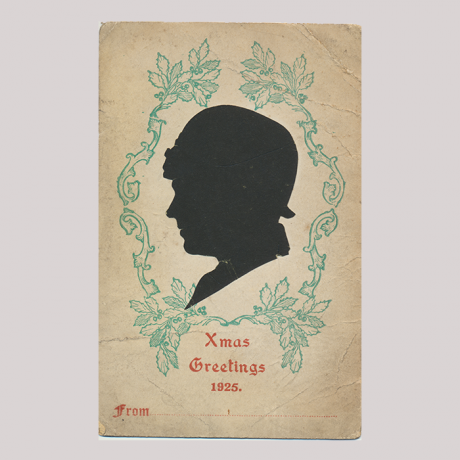 
        Front of silhouette, with woman looking left, wearing a hat, in decorated frame with floral motif. In the bottom inscription, Xmas Greetings 1925...