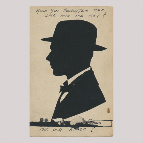 
        Front of silhouette, with man looking left, in suit and wearing a hat, some hand-written inscriptions in top and bottom.