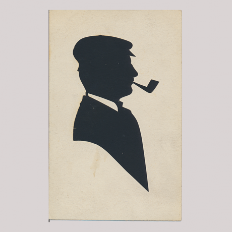 
        Front of silhouette, with man looking right, in suit, wearing a hat and smoking a pipe.