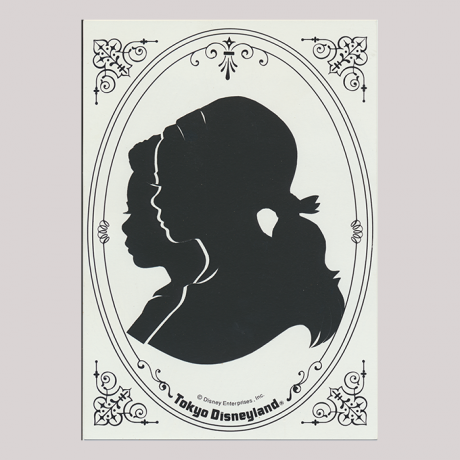 
        Front of silhouette, with two kids overlapping looking left, in rounded frame, in coreners decorations, inscription in bottom with, Tokyo Disneyland.